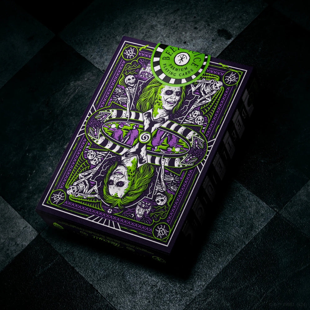 Deck of Beetlejuice playing cards laying on a dirty black and white chequered floor