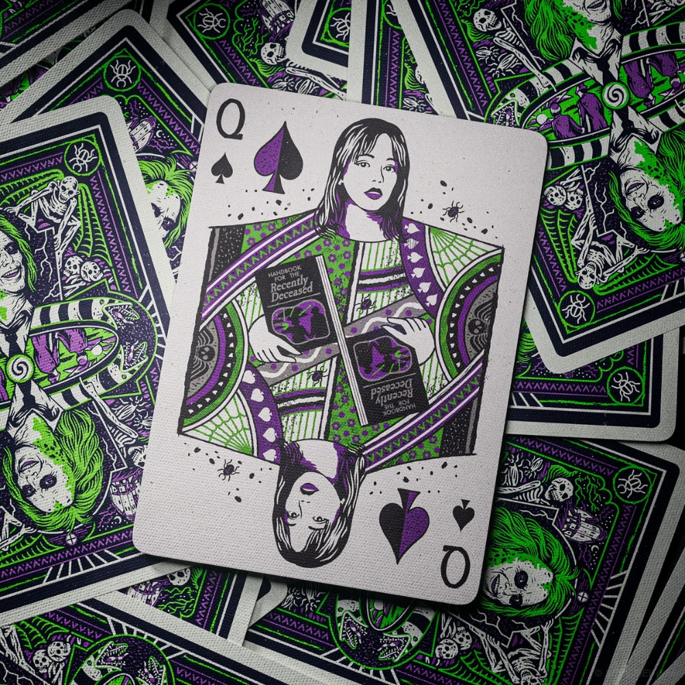 Queen of spades card, taken from a deck of Beetlejuice playing cards, set on drop of a scattering of face down playing cards
