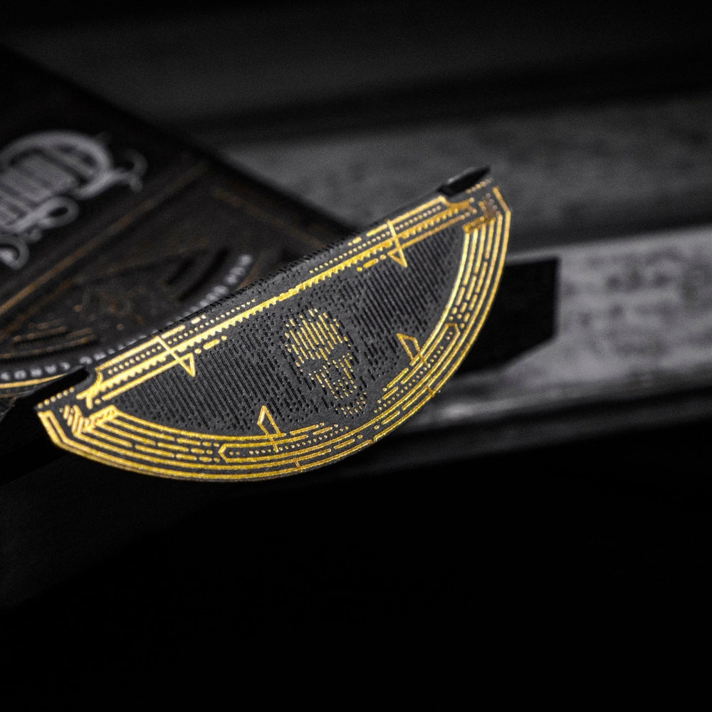 inside flap of the deck box from a set of Contraband playing cards. Features a partially obscured skull in black and gold
