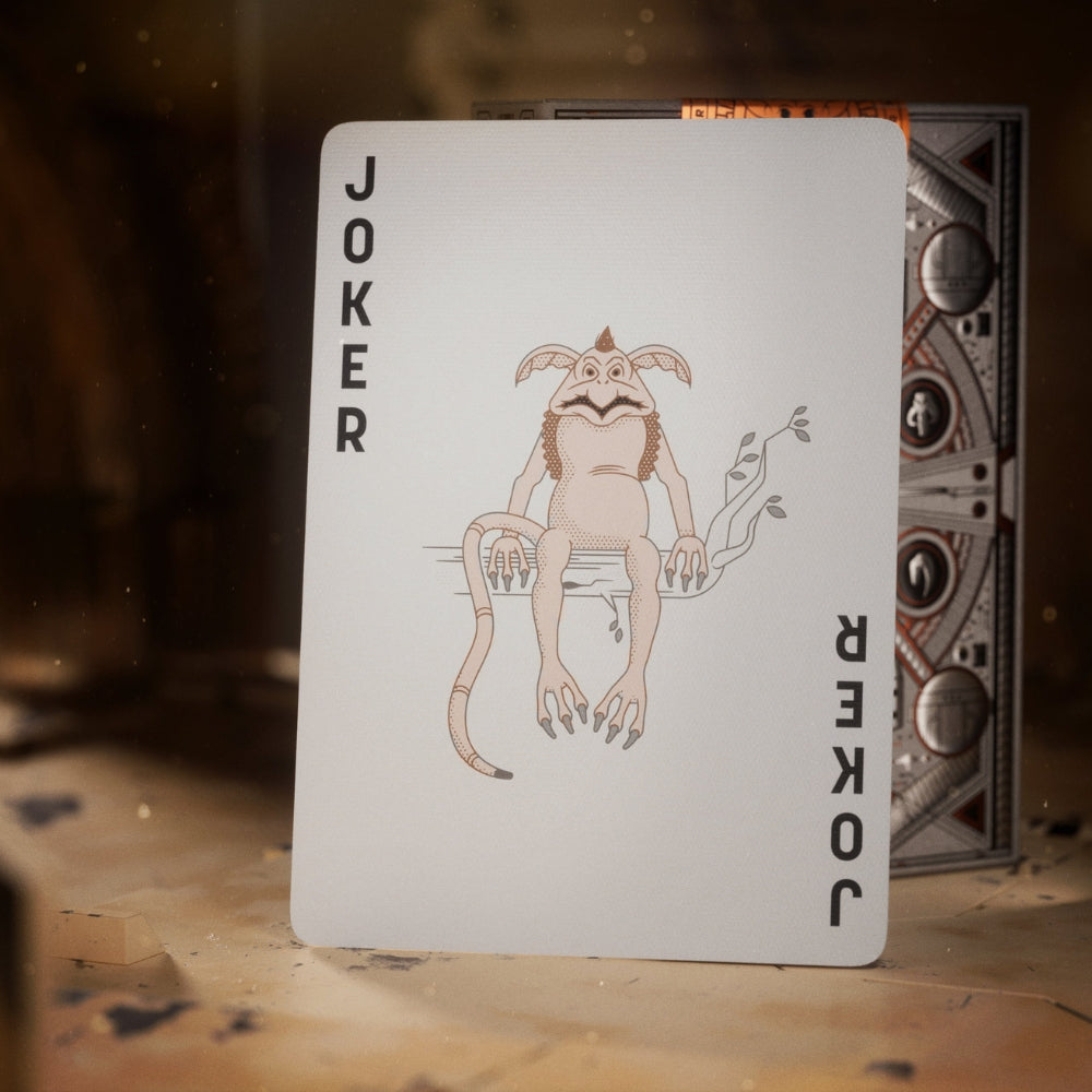 Joker card, leaning against a deck box of Mandalorian playing cards.