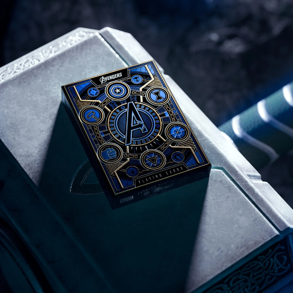 a pack of avengers playing cards, resting on something that looks like thors hammer