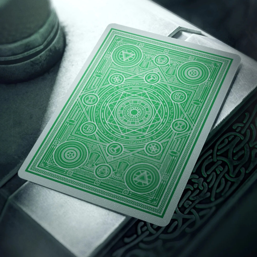 Back of an avengers playing card (green), resting on what looks like Thors hammer