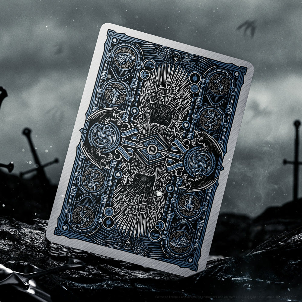 Back of a playing card, taken from a Game of thrones set. The card is standing up in the middle of a battle field, with the silhouette of a dragon in the sky