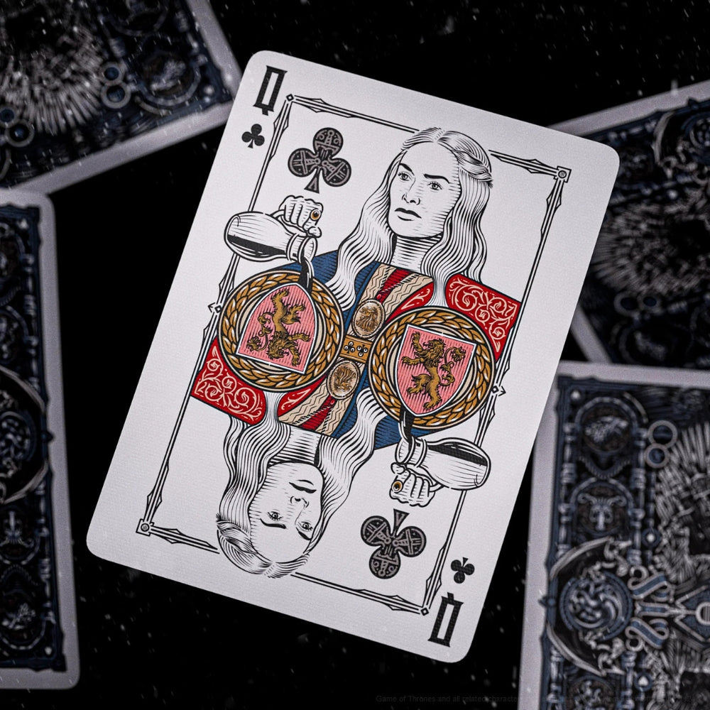 Queen of clubs card laying on a black surface ontop of four facedown cards. All cards taken from a set of game of thrones playing cards