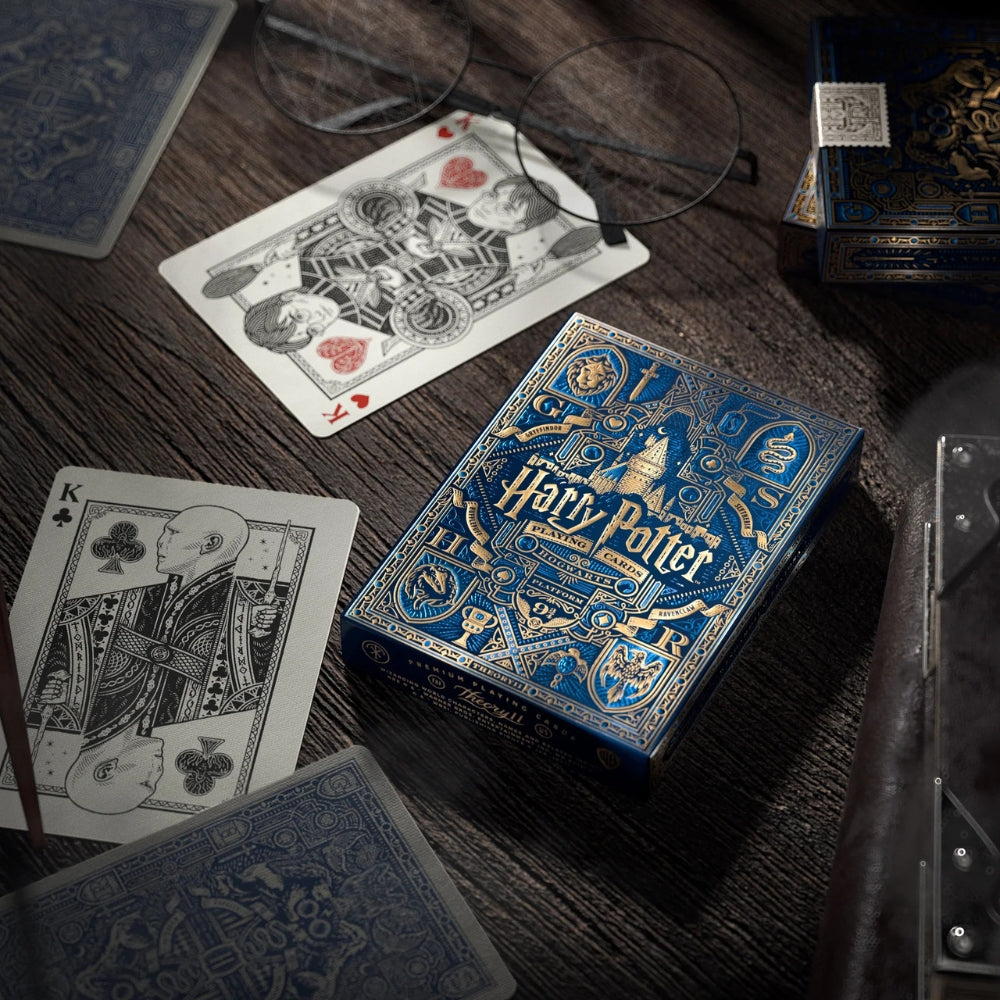 Picture of the Ravenclaw Harry potter deck box and two face cards on an old wooden desk, also features a pair of Savile Row Warwick styled glasses