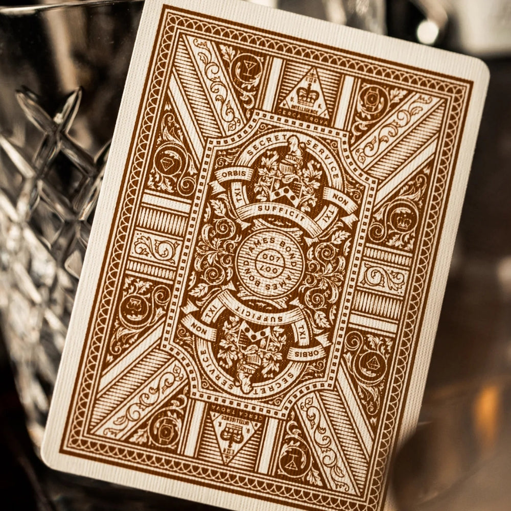 Close up of the back of a james bond playing card, leaning against an empty whisky glass.