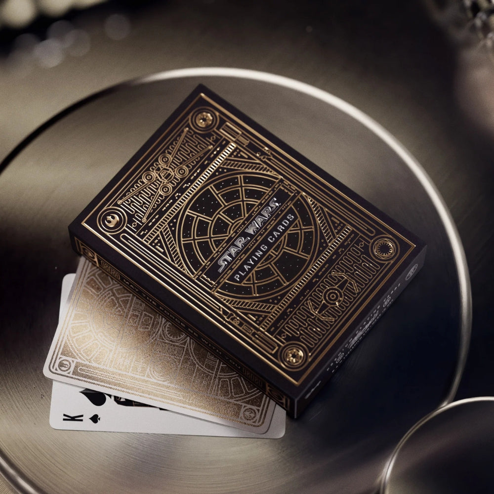 A deck box, a face down card and a king of clubs, all from a deck os star wars playing cards, all stacked on top of each other