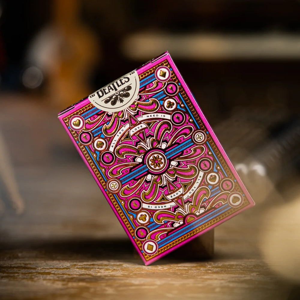 sealed deck of The Beatles playing cards (pink) tilted at an angle