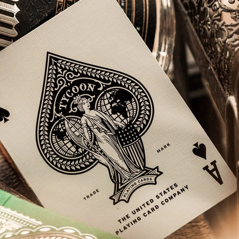 Ace of spades from a set of tycoon playing cards, with ornate items in the background