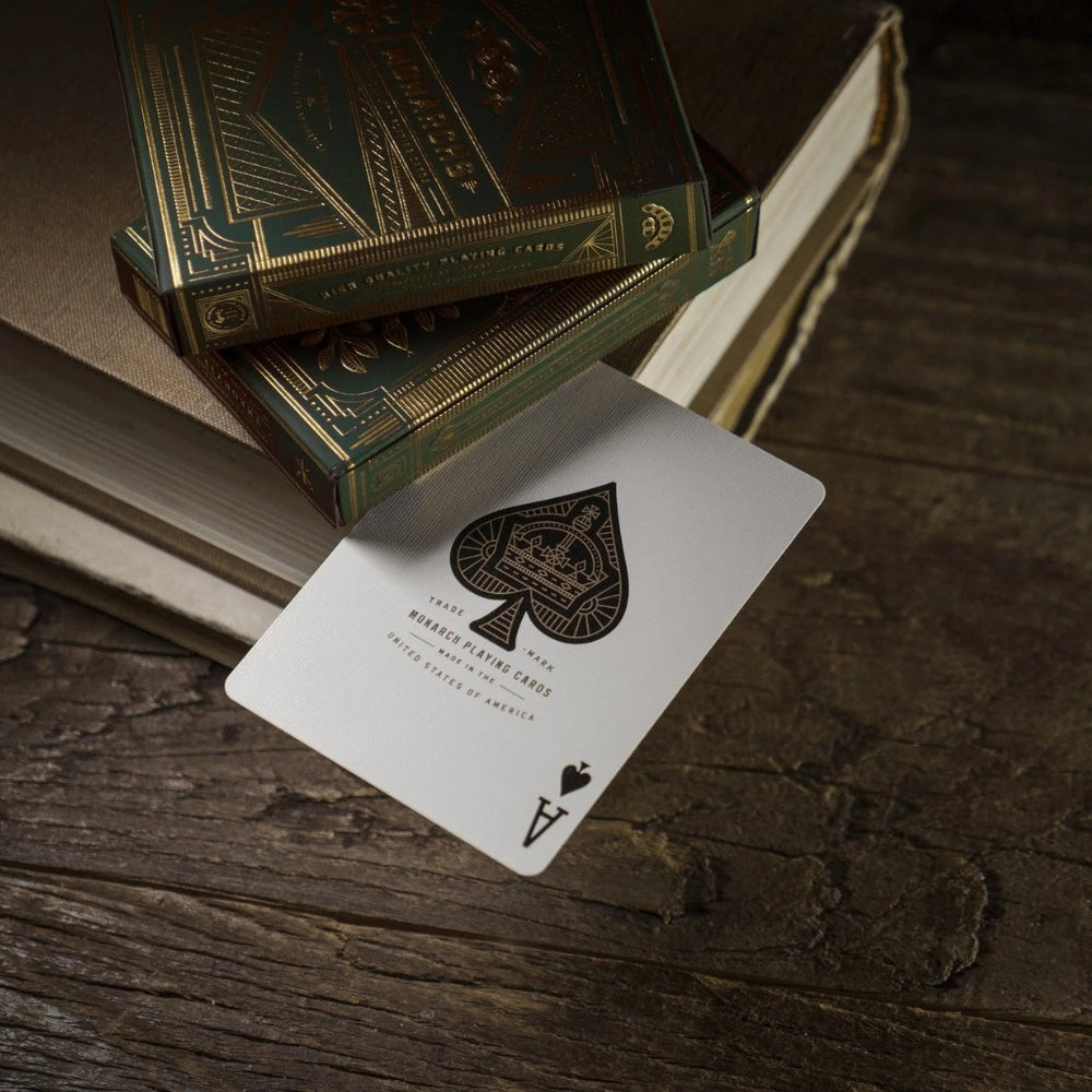 Ace of spades from the green monarch playing cards set, sandwiched between 2 deck boxes and a hard back book