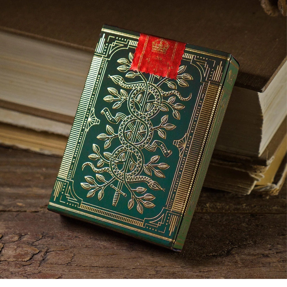 Sealed deck of green monarch playing cards on a wooden deck, leaning against two hardback books