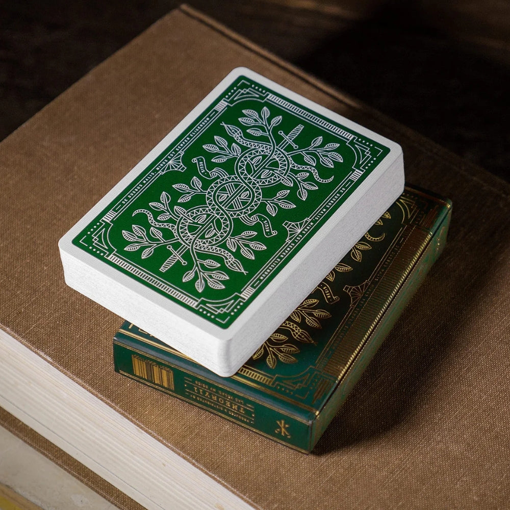 stack of green monarch playing cards, on top of a box, which is in turn on top of two hard back books