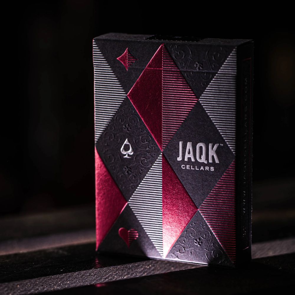 JaQK rose limited edition playing cards - single deck box on a black wooden surface