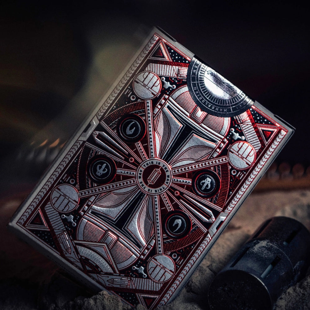 Back of a deck of Mandalorian playing cards, standing on its side in some sand