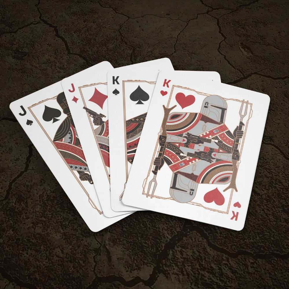 Fan of four face cards from the mandalorian playing cards deck, all on a dry cracked ground