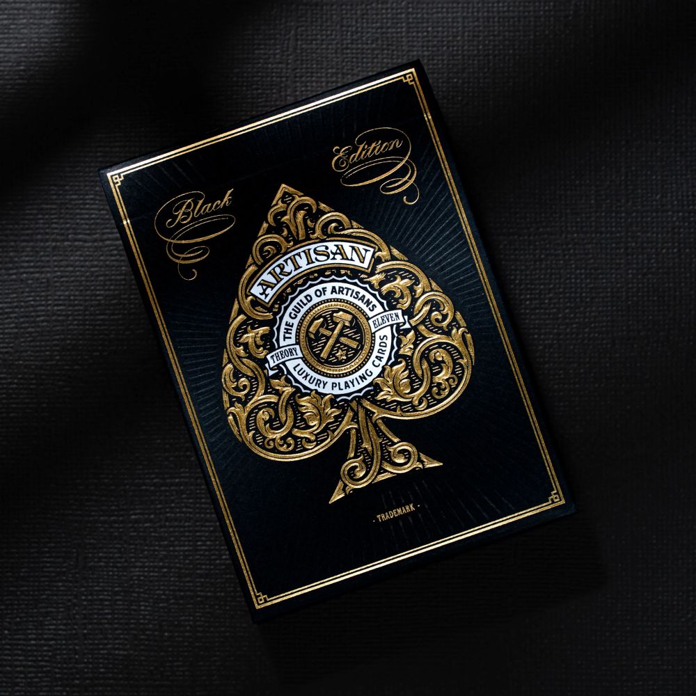 artisan playing cards, single black edition deck box on a dark material backdrop