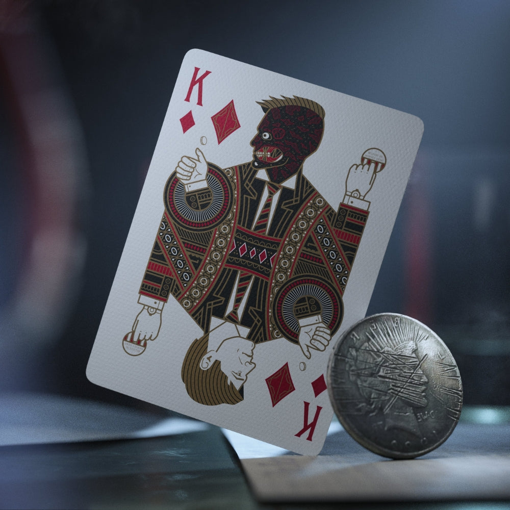 king of diamonds card from the batman playing cards deck, with a scuffed metal coin standing with it