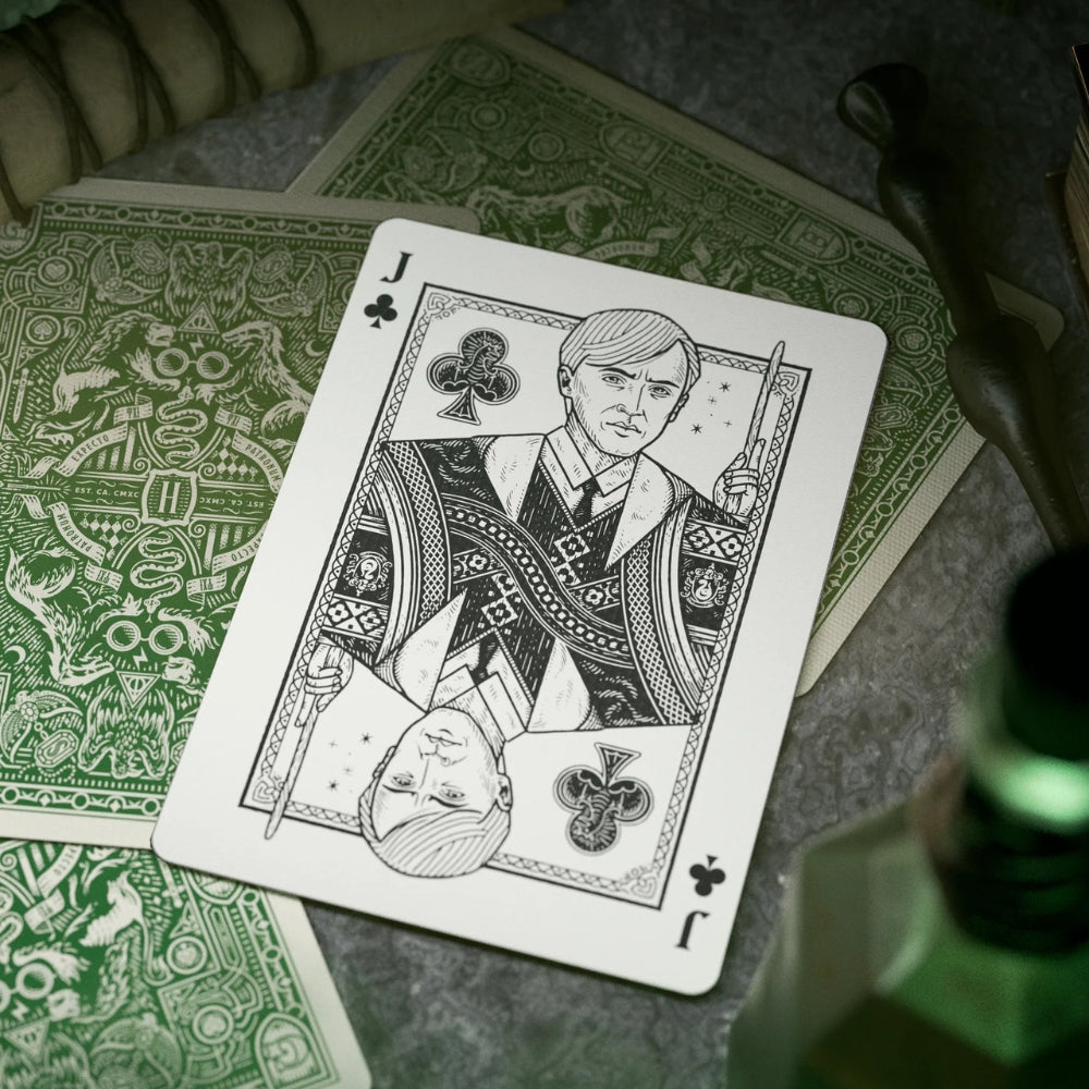 Jack of clubs laying over three facedown harry potter playing cards from the Slytherin deck