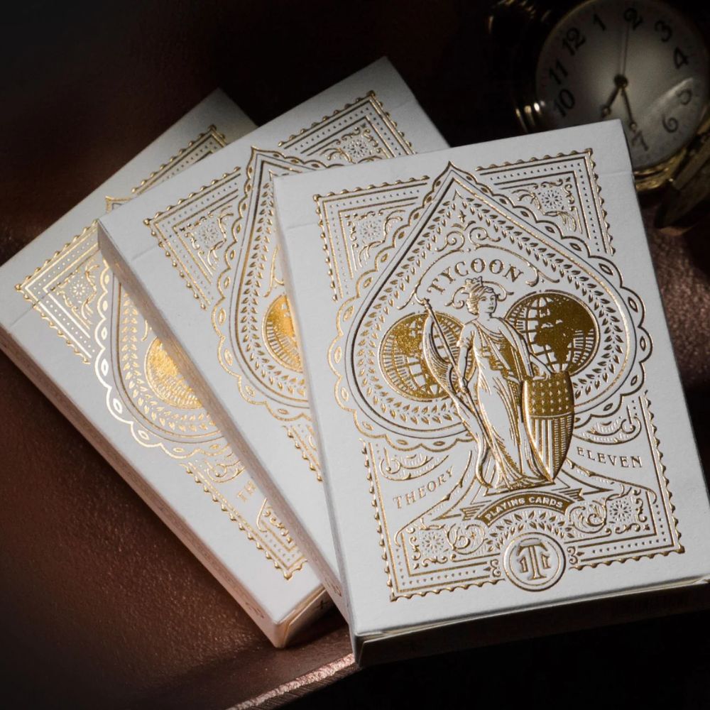 Tycoon playing cards - Ivory - three deck boxes on a leather looking surface