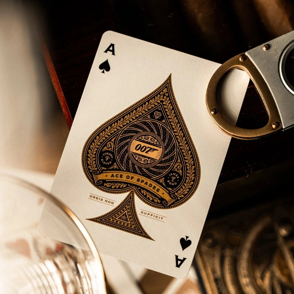Ace of spades from a james bond playing cards deck, also partially in the shot are a glass and cigar cutter