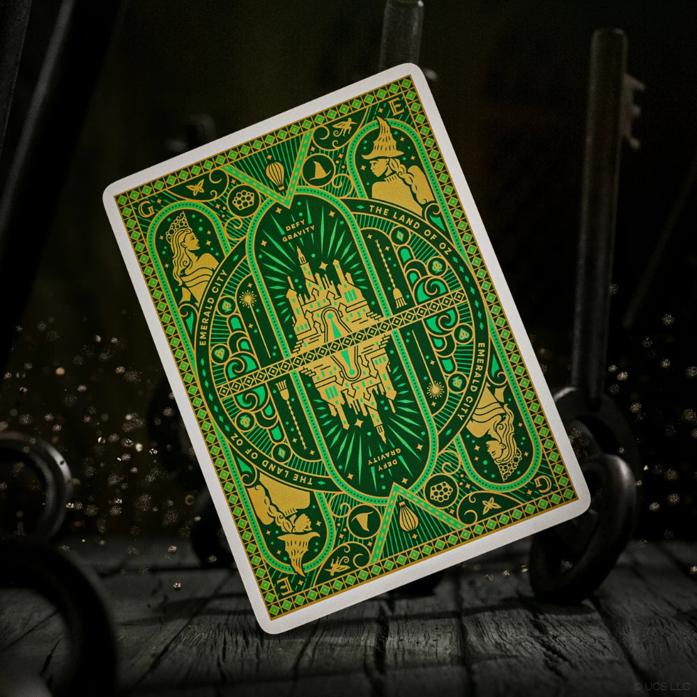 back of a wicked playing card, on a dark wooden surface with ornate keys in the background